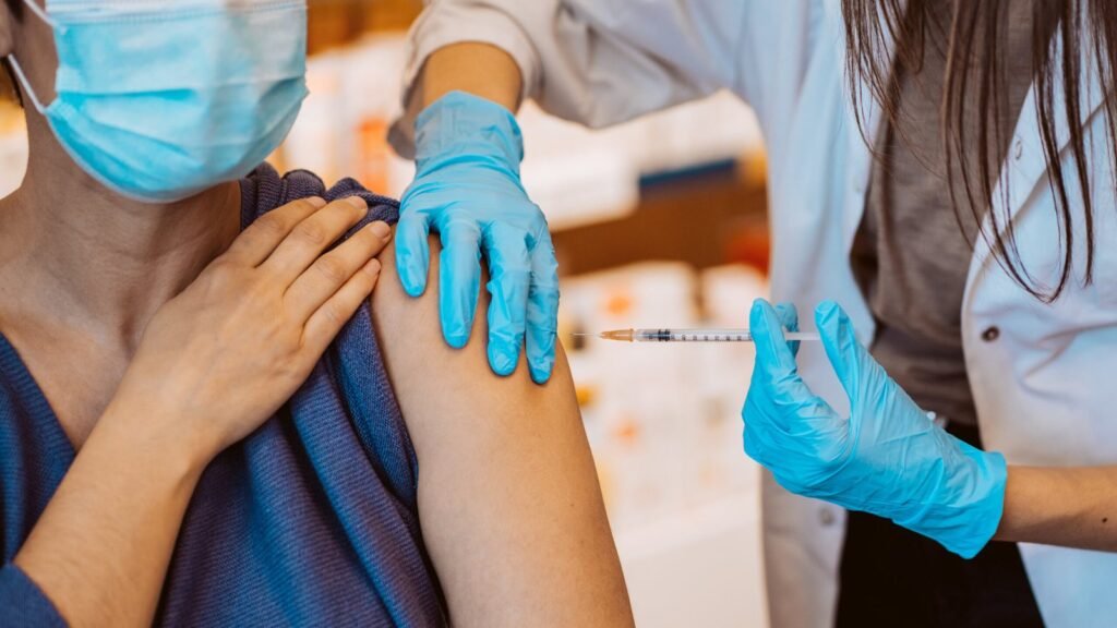 Traveler receiving a flu shot from a nurse